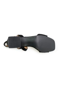 Zwarte suède hoge hak schoenen met een vierkante punt, tekstuur rubberen zool en enkelbandje. Voorzien van een gladde, gebogen vorm en een minimalistisch ontwerp.
