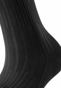 Schwarze Socken mit geripptem Muster und geschwungenen Linien. Hergestellt aus einem glatten, elastischen Material; entworfen für Komfort und Passform.
