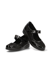 Zapatos Mary Jane de charol negro con tacones de cuña bajos y correas ajustables, exhibidos sobre un fondo blanco.