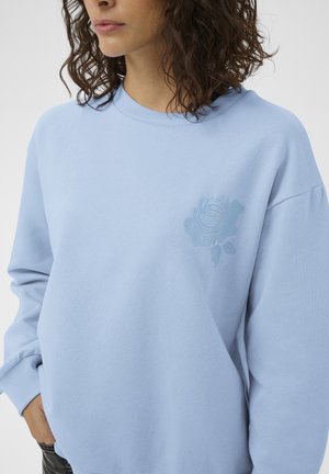 Hellblaues Sweatshirt aus weichem Stoff, mit einer Rosenstickerei auf der linken Brust, mit lockerem Schnitt und langen Ärmeln.