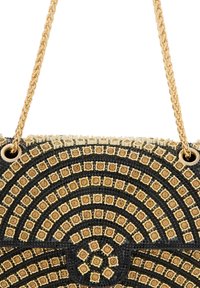 Czarna torebka z złotymi okrągłymi ozdobami i strukturalną powierzchnią. Posiada złotą łańcuszkową rączkę i sztywny kształt.