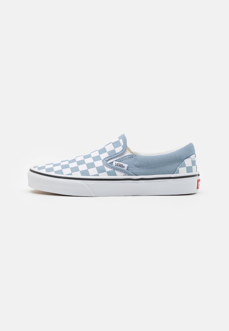 Baskets basses à enfiler avec motif damier bleu et blanc et semelle en caoutchouc blanche, avec une petite étiquette logo Vans sur le côté.