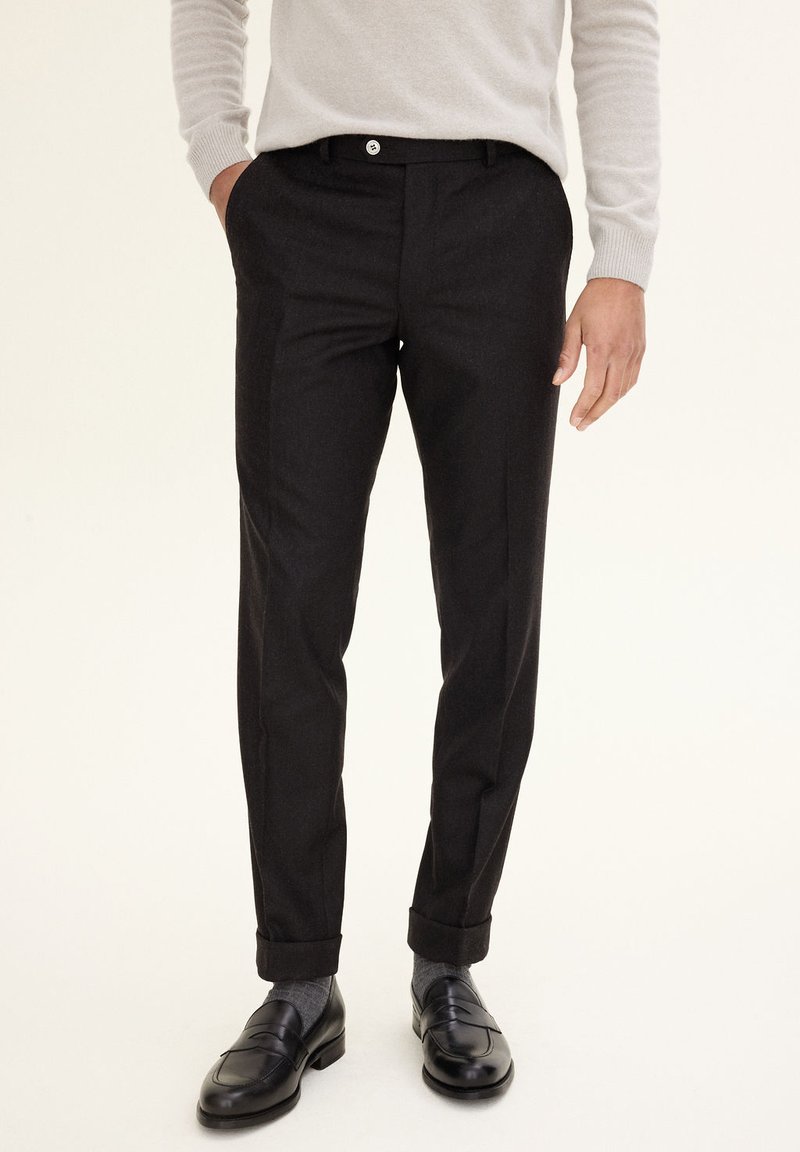 Black tailored trousers with a smooth texture, featuring a slim fit, cuffed hems, and a front button closure for a polished look.