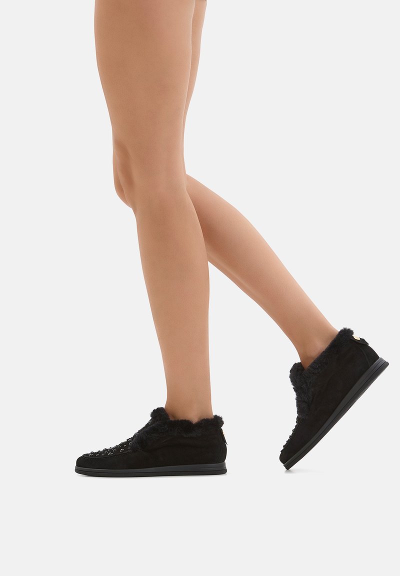 Schwarze Wildlederschuhe mit Fellbesatz, niedriges Profil-Design und strukturierten Details im Obermaterial. Gummisohle für Grip und Langlebigkeit.