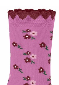 Różowa skarpetka z falbanką na górze, ozdobiona kwiecistym wzorem z bordowymi i jasnoróżowymi kwiatami oraz zielonymi liśćmi.