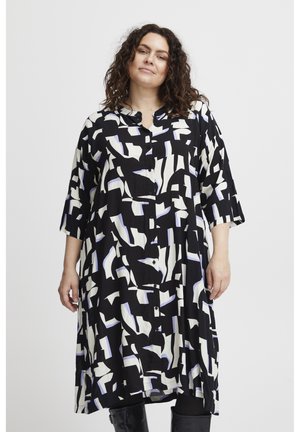 Vestido de patrón en blanco y negro con formas abstractas y detalles en azul claro, con cierre de botones en el frente y mangas de tres cuartos. Tejido suave.