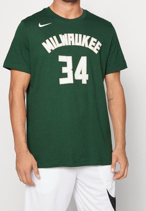 Groen Milwaukee basketbalshirt met nummer 34, gedragen door een persoon met zichtbare armen en witte shorts.