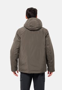 Padded jacket in olive green with a large hood, featuring a smooth texture and concealed seams, designed for warmth and comfort.