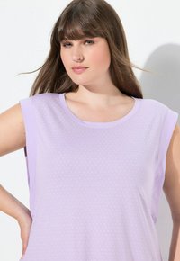 Top senza maniche color lilla con scollo rotondo, caratterizzato da un tessuto texturizzato e piccoli punti bianchi su tutto il capo. Materiale morbido e flessibile.