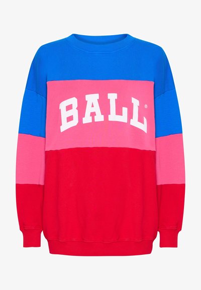 Kratkā piedurkne džemperis ar krāsu blokiem, kas satur zilos, rozā un sarkanos sektorus. Priekšpusē ir vārds "BALL" bieziem baltajiem burtiem. Garas piedurknes, apaļa kakla izgriezums.