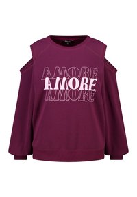 Sweat-shirt bordeaux avec découpe épaules dénudées, portant le texte répété « AMORE » en blanc contrastant. Tissu doux avec poignets côtelés.
