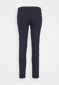 Donkerblauwe skinny jeans met een gladde textuur, voorzien van twee achterzakken en subtiele merkindicatie bij de tailleband.