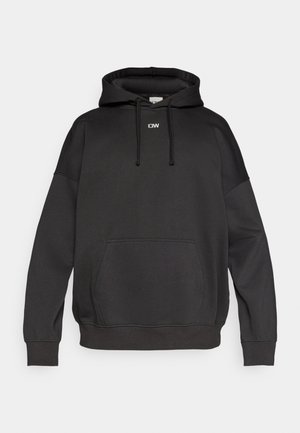 Črna kapuca iz mehke tkanine. Ima sprednji žep, vrvice za zategovanje in majhen logotip na prsih. Sproščen kroj, rebrasti manšeti.