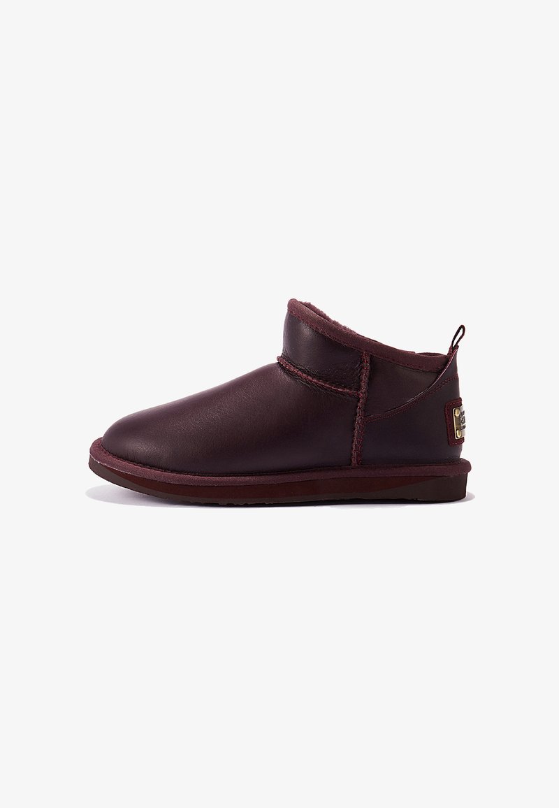 Bordeaux leren enkelboots met een ronde neus, voering van schapenwol en gestikte details; lage rubberen zool met een merkaccent op de hak.