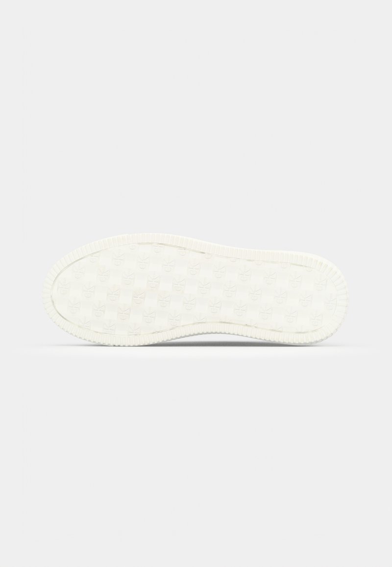 Semelle en caoutchouc blanche de sneakers présentant une surface texturée avec des motifs de logo répétitifs, des bords arrondis et un côté rainuré pour une meilleure adhérence.