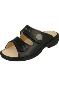 Zwarte leren slide sandaal met open teen, twee verstelbare banden, decoratieve ronde hardware, beige inlegzool en een lage hak.