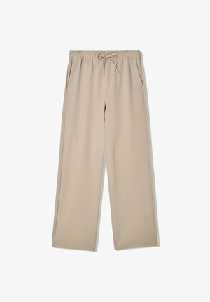 Beige wide-leg pants with elastic waistband and drawstring, featuring side pockets, laid flat on white background.