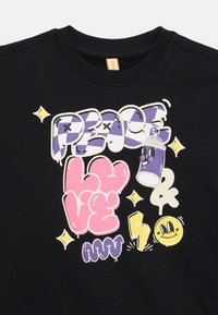 Zwarte sweatshirt met een graphic print met meerkleurige tekst: "VREDE," "LIEFDE," en glimlachaccenten. Zachte textuur met een ribgebreide kraag.