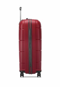 Maleta rígida roja con surcos horizontales, mango extensible y cuatro ruedas negras. Cierre en el medio, diseño elegante.