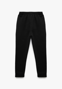 Zwarte sweatpants gemaakt van zacht materiaal, met een elastische tailleband, taps toelopende pijpen en ribbels aan de enkels.