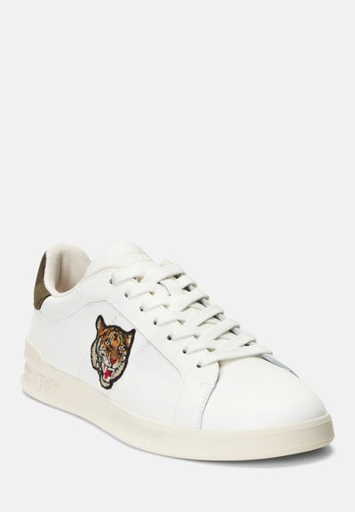 Sneakers bianchi in pelle con ricamo di tigre sul lato, lacci piatti e un accentuato tallone verde oliva.