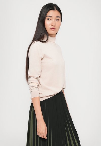 Light pink, knit sweater with a high neckline and long sleeves, paired with a black pleated skirt. Soft texture and relaxed fit.
