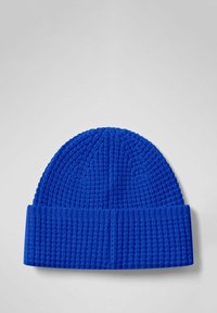 Berretto lavorato a maglia di un blu brillante con risvolto e texture a nido d'ape su uno sfondo chiaro.