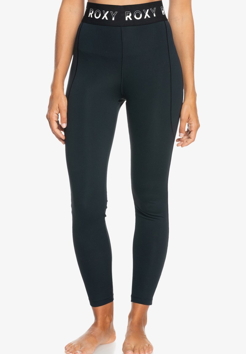 Leggings neri a vita alta con un elastico in vita con logo Roxy, realizzati in un tessuto liscio e aderente che si estende fino alle caviglie.