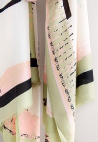 Sciarpa leggera con una texture morbida, caratterizzata da un mix di motivi astratti in rosa, verde e nero e bordi sfrangiati.