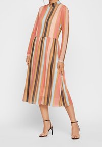 Długa, A-liniowa sukienka z długim rękawem, wykonana z przezroczystego materiału w pionowe paski w kolorze różowym, brązowym i niebieskim. Posiada wysoki dekolt i boczne rozcięcie.