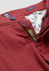 Rote Baumwollhosen mit Reißverschluss, Knopfverschluss und blauen Akzenten. Das Innenfutter hat ein gemustertes Design. Enthält Markentags.