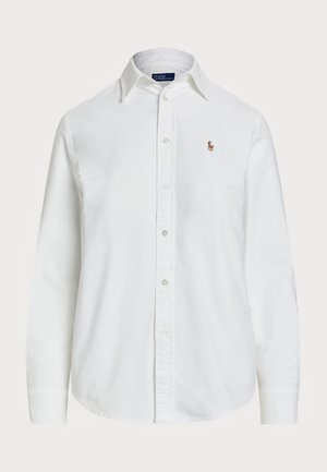 Camisa branca de botão, feita de algodão, com colarinho clássico, mangas longas e um pequeno logótipo bordado no peito. Tecido texturizado.
