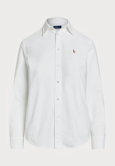 Camisa blanca de botón hecha de algodón con cuello clásico, mangas largas y un pequeño logo bordado en el pecho. Tejido texturizado.