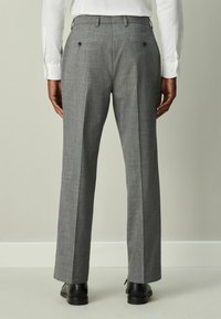 Sivé nohavice s vzorom, priamym strihom, dvoma zadnými vreckami s gombíkmi a textúrovanou látkou.