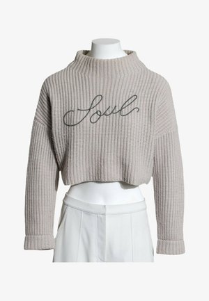 Jersey corto gris tejido con cuello alto y mangas largas, con la palabra "Soul" bordada en el frente en letra cursiva.
