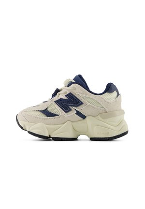 Beige og marineblå atletiksneaker med meshpaneler, ruskindsoverlejringer, tyk tekstureret sål og stort "N"-logo på siden.