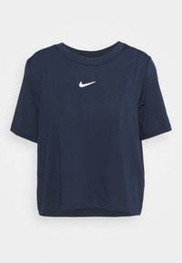 Marinblå kortärmad croppad t-shirt i texturerad tyg. Har en vit Nike-logga på bröstet och rund halsringning.