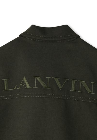 Donkergroene stof met gestikt "LANVIN" tekst in bijpassende draad over de bovenrug onder de kraag.