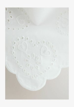 White fabric with scalloped edges featuring embroidered heart and floral patterns in matching white thread.