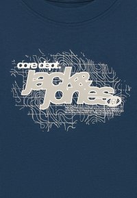 Marine T-skjorte laget av bomull med et stort hvitt grafisk design med teksten "jack&jones" og et bølgete linjemønster.