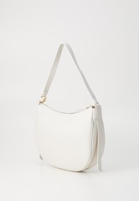 Borsa a spalla bianca realizzata in pelle testurizzata con forma curvata, hardware dorato e tracolla sottile. Chiusura con zip e dettagli laterali.