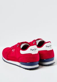 Sneakers in suede rosso con dettagli in pelle bianca, stampa del logo sul tallone, design con lacci e suola in gomma con battistrada grigio.
