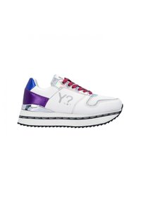 Sneaker bianco con accenti viola e blu, elementi riflettenti argentati, lacci rosa e una suola a fantasia in bianco e nero.