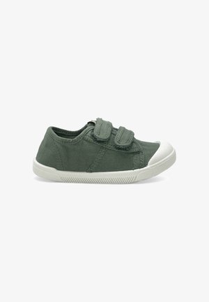 Basket basse en toile verte avec deux bandes Velcro réglables et un bout ainsi qu’une semelle en caoutchouc blanc.