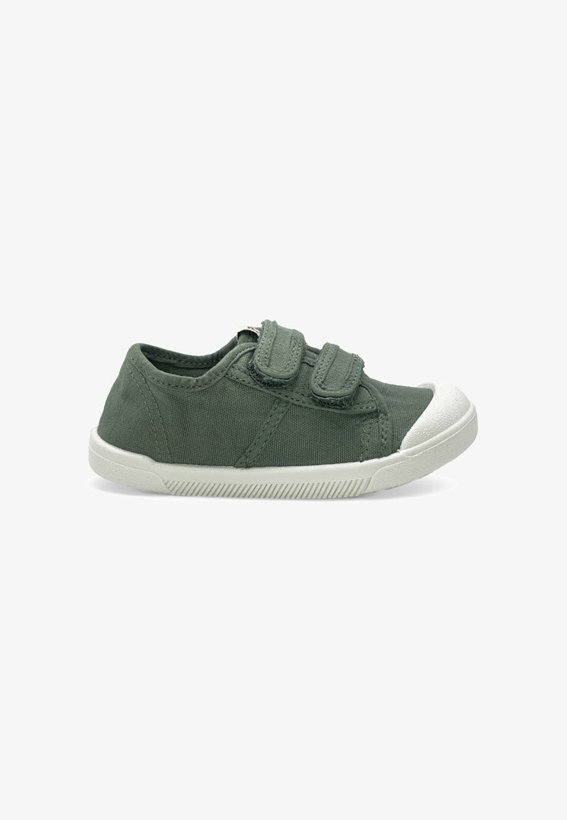 Basket basse en toile verte avec deux bandes Velcro réglables et un bout ainsi qu’une semelle en caoutchouc blanc.
