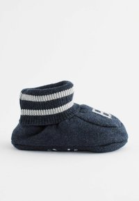 Navy-kankaan saappaat valkoisella raidallisella resorilla, pyöreä kärki ja teksturoitu pohja pidon takaamiseksi. Klassinen kuvio edessä.