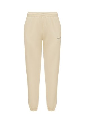 Vékony anyagból készült bézs melegítőnadrág, rugalmas derékpánttal, passzos bokákkal és kis márkajelzéssel elöl. Klasszikus szabású.