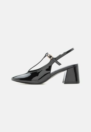 Zwarte lakleren slingback met lage hak, spits toelopende neus en T-bandje met kleine gouden gesp.