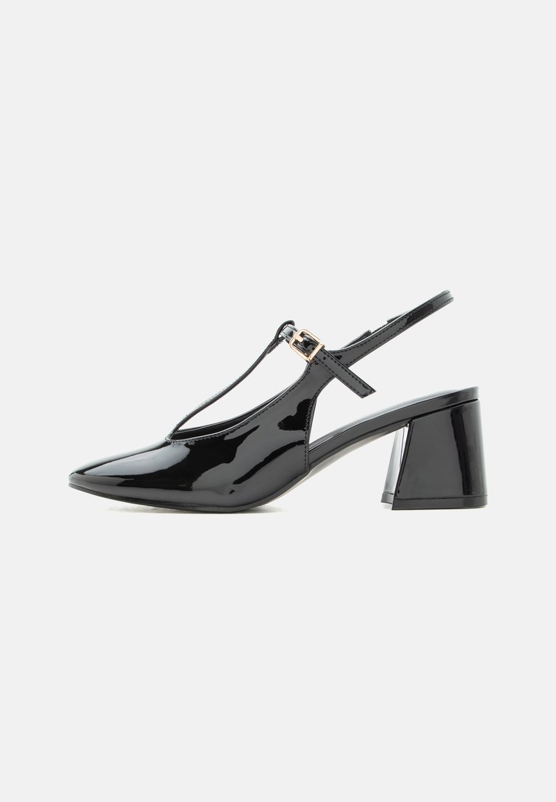 Chaussure slingback en cuir verni noir à petit talon, bout pointu et bride en T avec une petite boucle dorée.