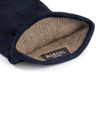 Navy blue glove with soft beige knitted lining, showing ROECKL München brand label inside wrist area.
